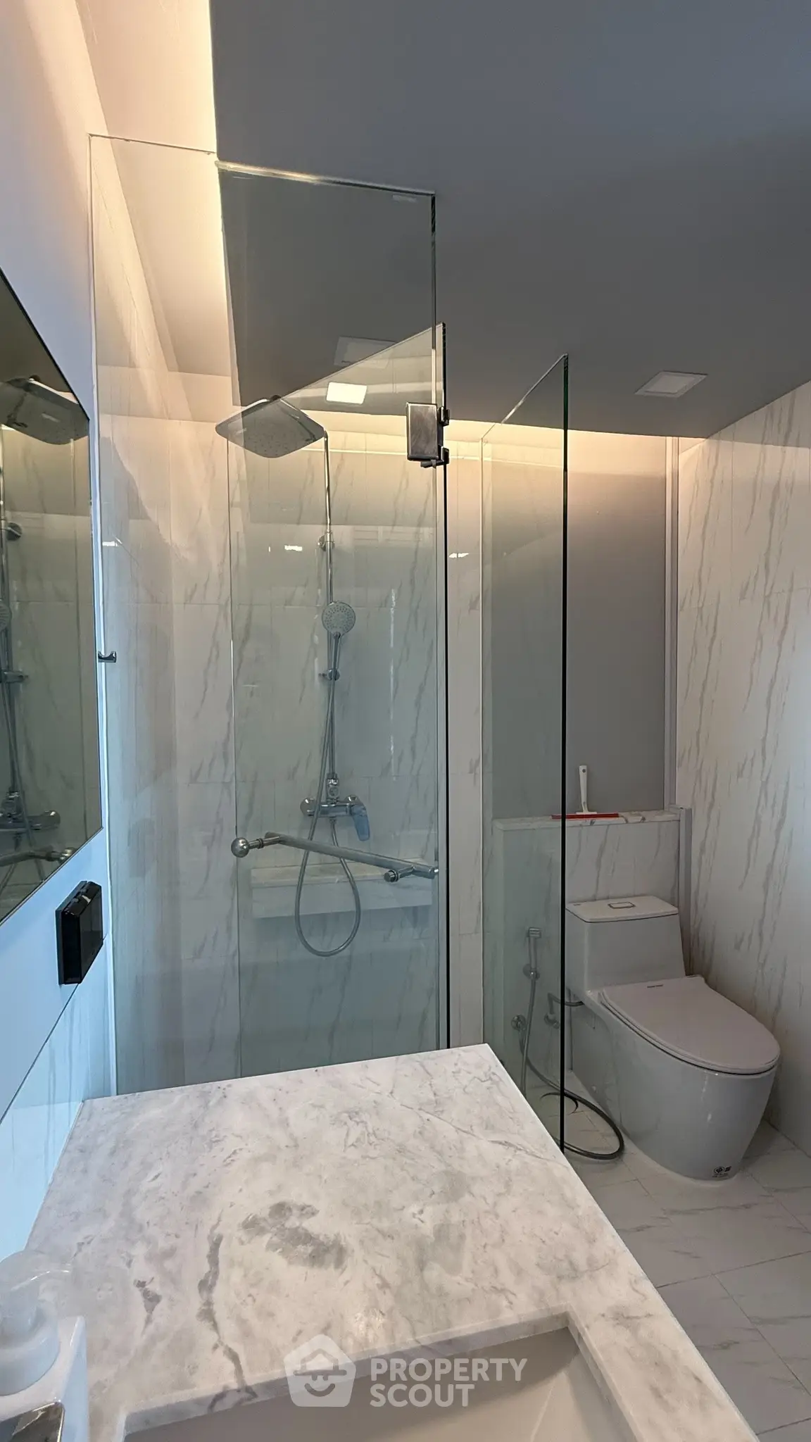 Modern bathroom with glass shower and marble countertop