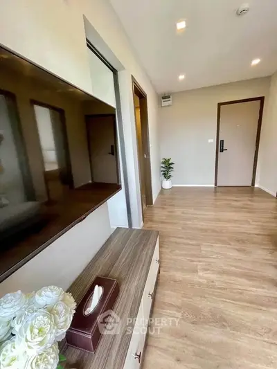 Modern living room with wooden flooring and sleek TV setup