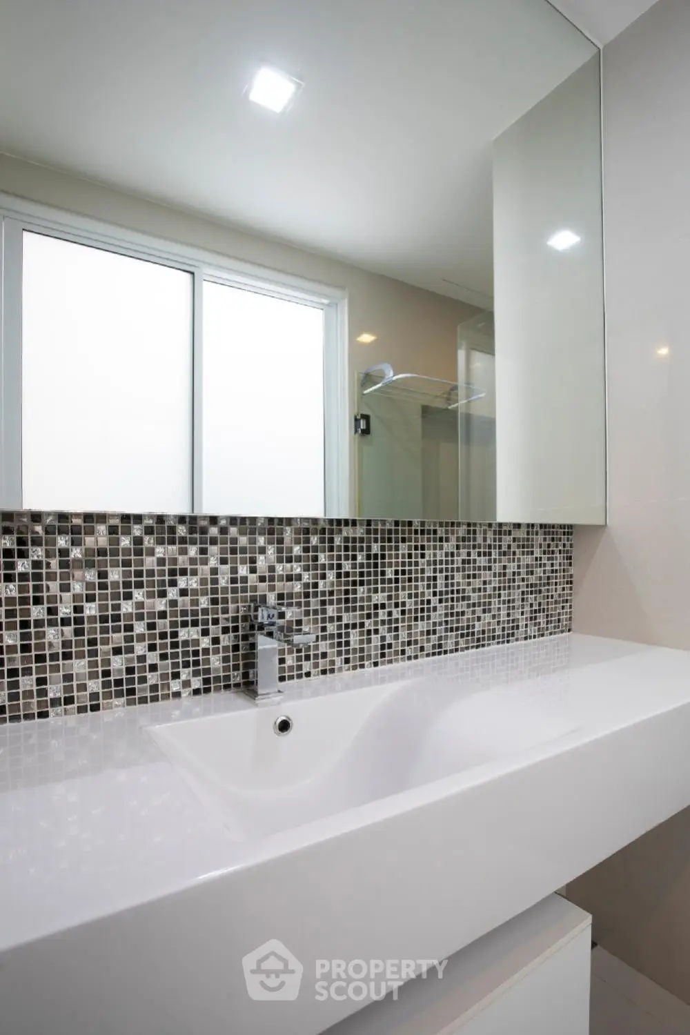 Modern bathroom with sleek sink and mosaic tile backsplash