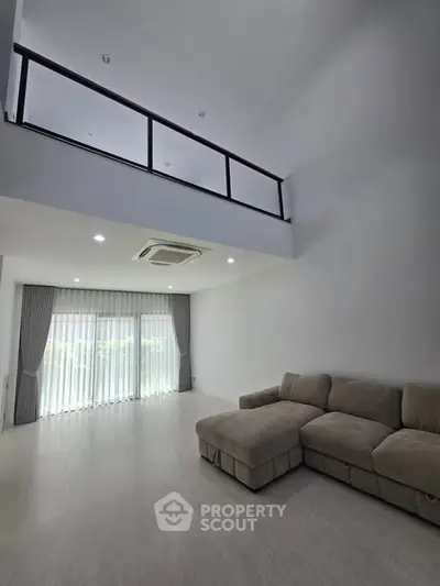Spacious modern living room with high ceiling and large windows