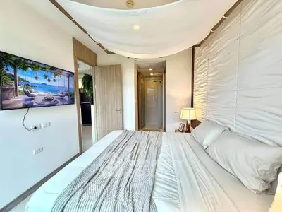 Luxurious bedroom with modern decor and wall-mounted TV, perfect for relaxation.