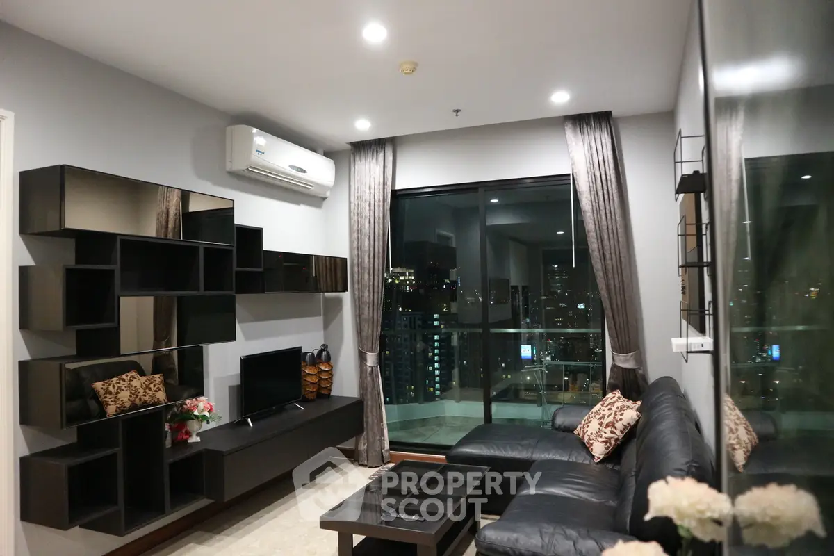 Modern living room with city view, sleek furniture, and stylish shelving in a high-rise apartment.