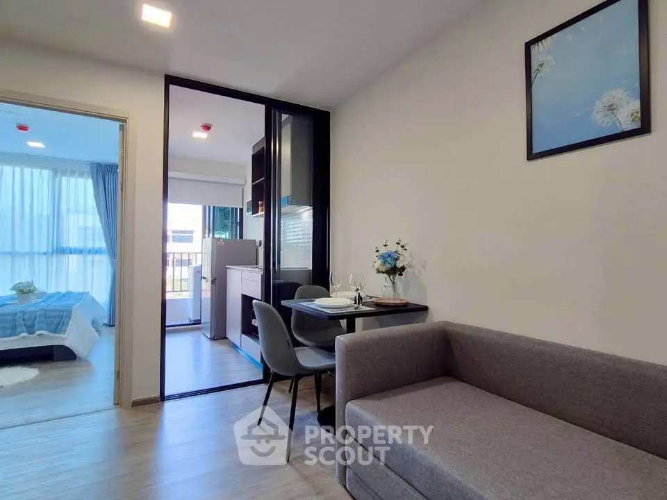 Modern apartment interior with cozy living room and stylish dining area, featuring a view into a bright bedroom.