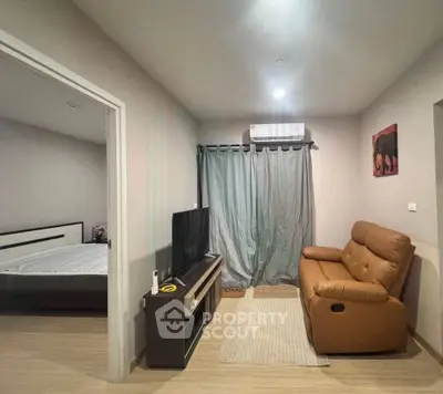 Cozy living room with modern furniture and adjacent bedroom view
