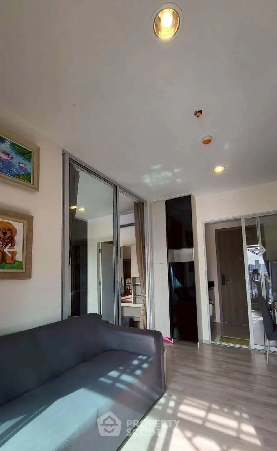 Modern living room with sleek design and ample natural light, featuring a cozy sofa and stylish decor.