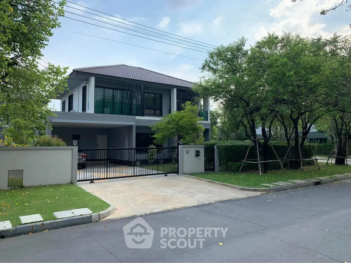 Elegant modern house with lush greenery and spacious driveway in a serene neighborhood.