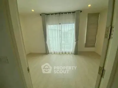 Spacious empty room with large window and elegant curtains