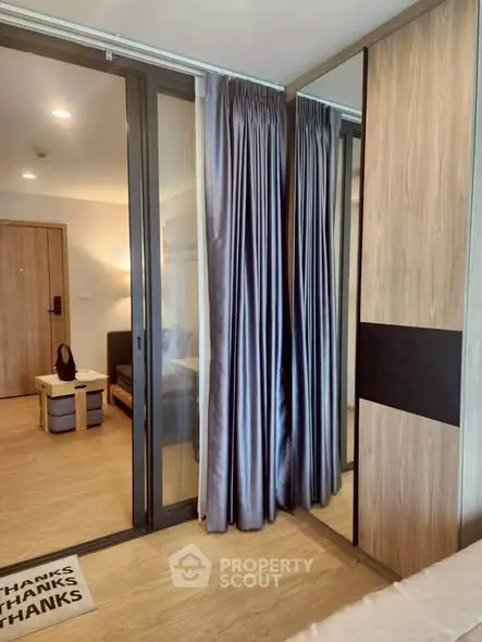 Modern apartment interior with sliding glass doors and elegant curtains, showcasing a cozy living space.