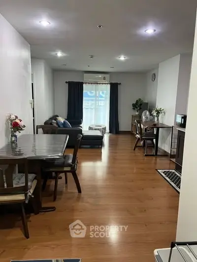 Spacious living room with elegant wooden flooring and modern furniture, perfect for comfortable living.