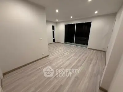 Spacious modern living room with sleek flooring and large sliding glass doors.