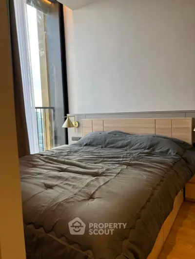 Modern bedroom with large window and stylish decor in urban apartment