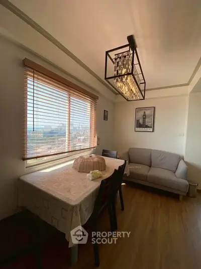 Charming dining area with city view, elegant chandelier, and cozy seating.