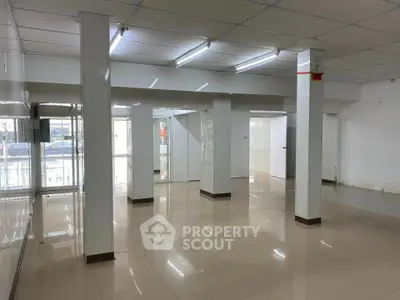 Spacious commercial space with tiled flooring and ample lighting, ideal for business setup.
