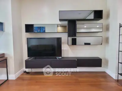 Modern living room with sleek wall-mounted TV and stylish shelving unit.