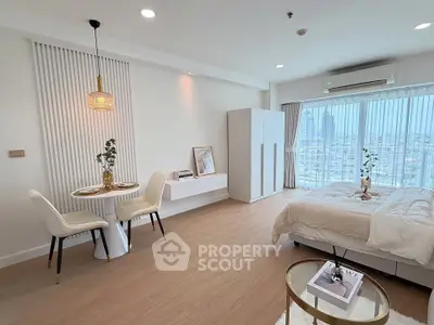 Spacious modern bedroom with city view, elegant decor, and cozy dining area, perfect for urban living.
