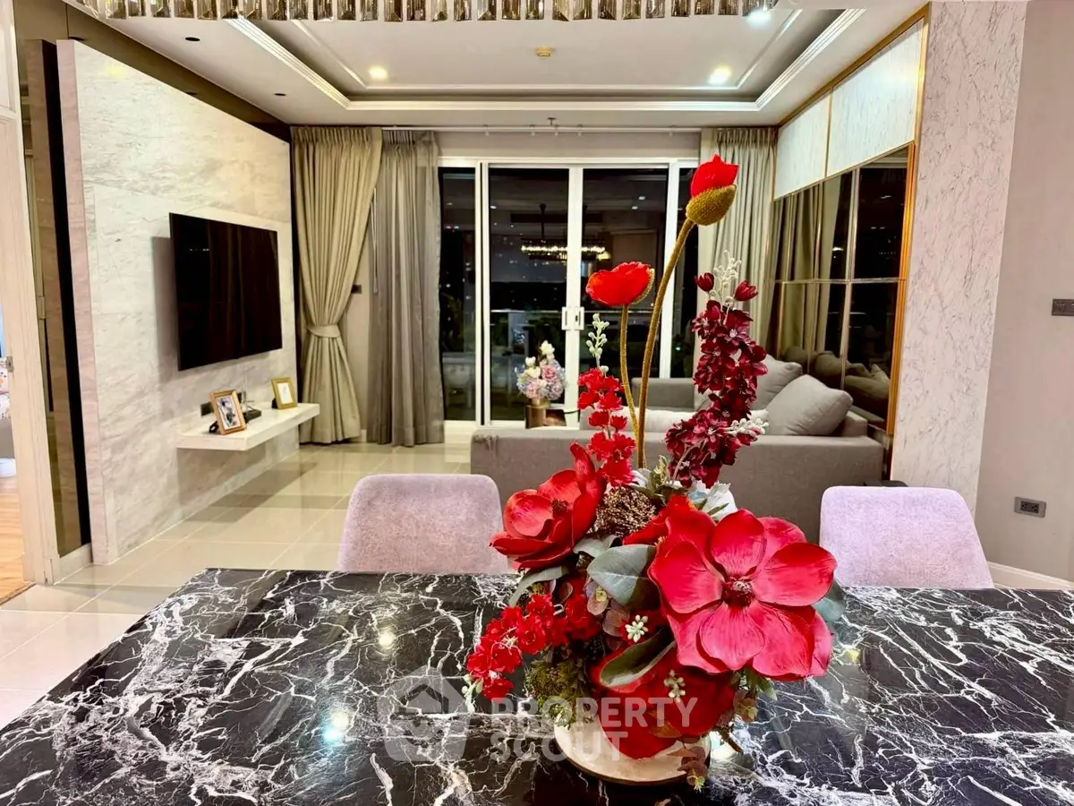 Luxurious living room with elegant decor and marble dining table, featuring a spacious layout and modern furnishings.