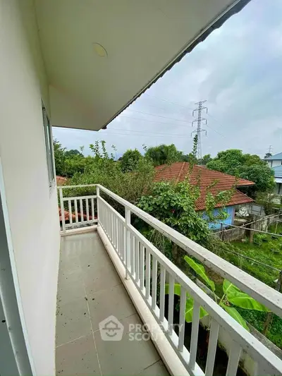 Charming balcony with lush garden view in serene residential area.