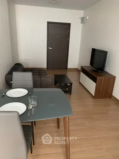 Modern living room with sleek furniture and wooden flooring in a cozy apartment.