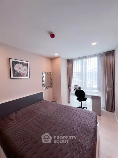 Modern bedroom with large window and study desk, featuring elegant decor and ample natural light.