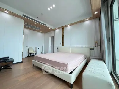 Spacious modern bedroom with elegant wooden flooring and large windows for natural light.