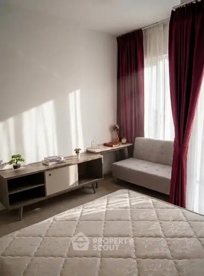 Cozy bedroom with natural light, modern furniture, and elegant curtains.