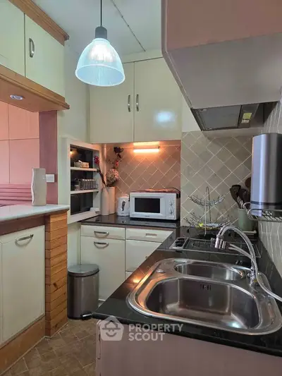 Charming kitchen with modern appliances and stylish lighting, perfect for culinary enthusiasts.