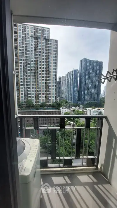 Urban balcony with washing machine and city view, perfect for modern living.