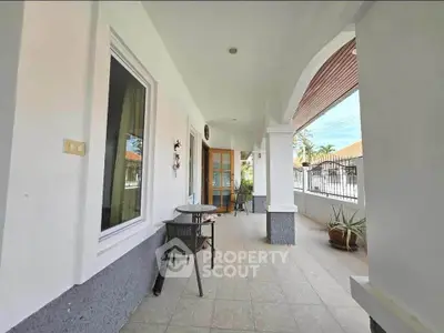 Charming patio with seating area and garden view, perfect for relaxation.
