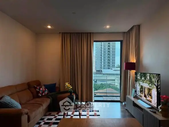 Modern living room with large window and city view, featuring stylish furniture and decor.
