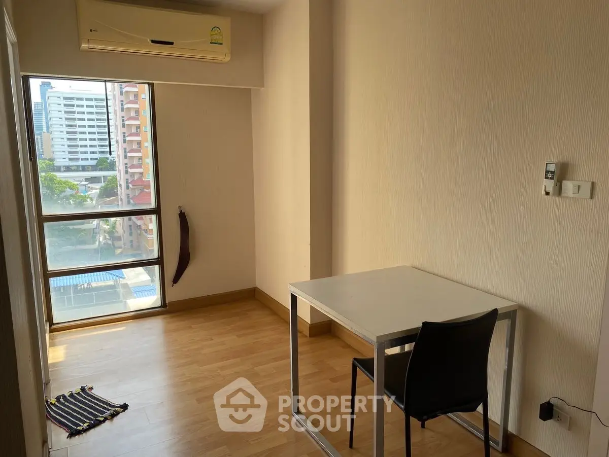 Minimalist study room with large window and air conditioning in urban apartment
