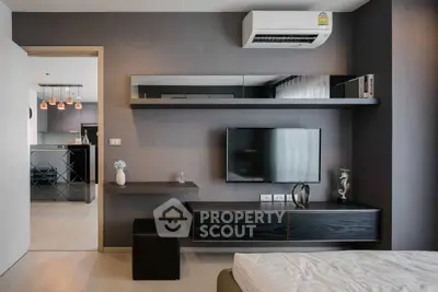 Modern living room with sleek design, wall-mounted TV, and stylish shelving in a contemporary apartment.