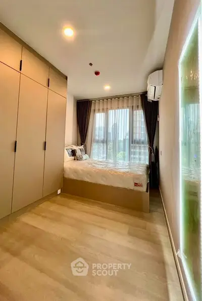 Modern bedroom with large wardrobe and natural light from window.