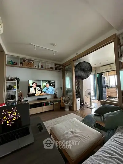 Cozy living room with modern decor and open layout leading to kitchen area.