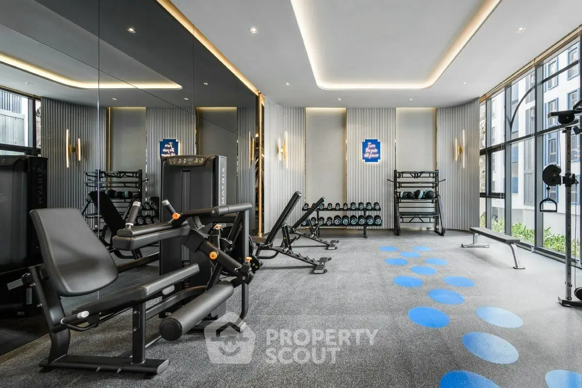 Modern gym with state-of-the-art equipment and mirrored walls in luxury apartment building.