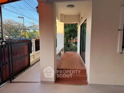 Charming exterior view of a modern home with a cozy entrance and lush garden.