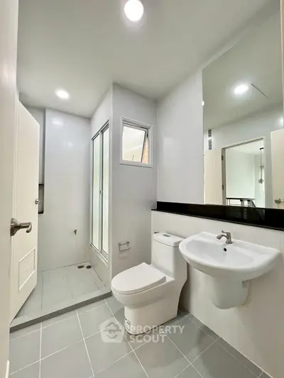 Modern bathroom with sleek fixtures and spacious shower in a contemporary home.
