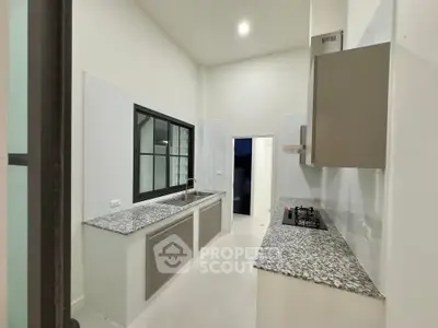 Modern kitchen with sleek countertops and gas stove, perfect for culinary enthusiasts.