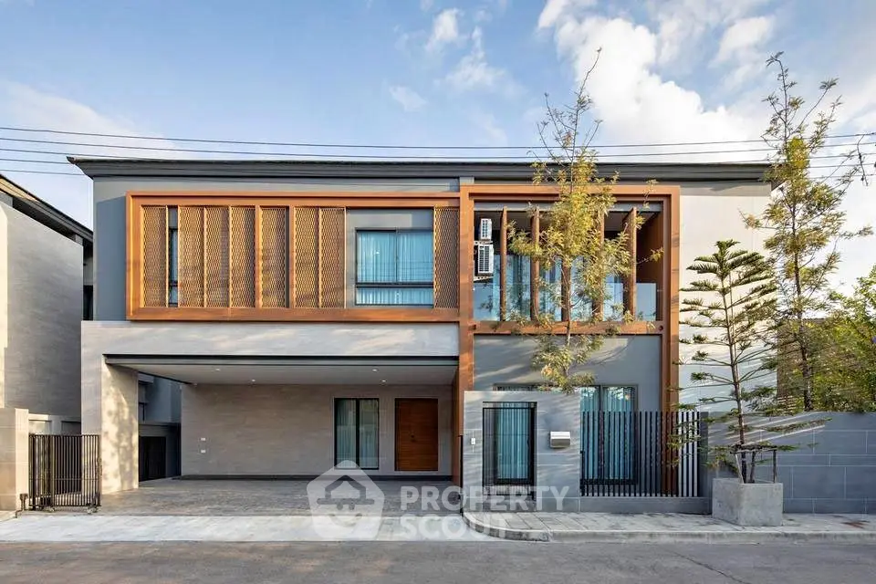 Modern two-story house with sleek design and spacious driveway.