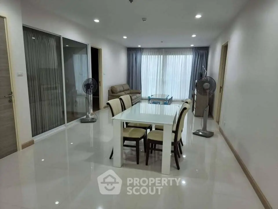 Spacious modern living room with elegant dining area and ample natural light.