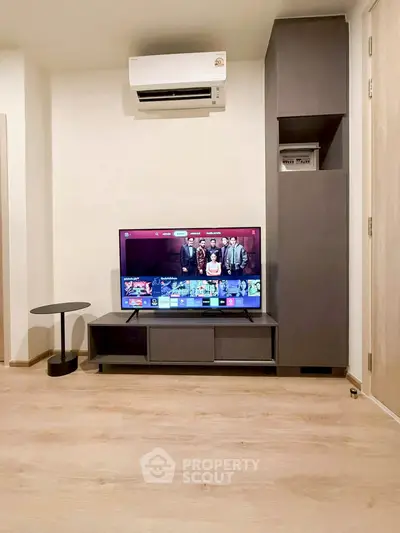 Modern living room with sleek TV setup and air conditioning unit.