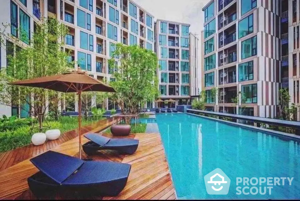 Luxurious modern apartment complex with stunning pool and lush greenery.