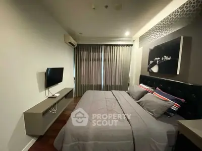Modern bedroom with stylish decor and wall-mounted TV in cozy apartment.