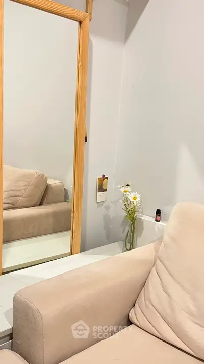 Cozy living room corner with beige sofa and wooden mirror