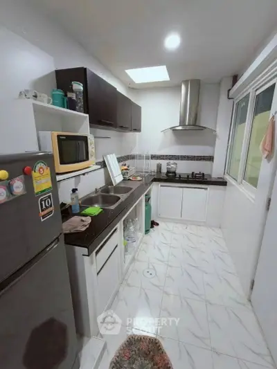 Modern kitchen with sleek cabinetry and gas stove, featuring a compact yet efficient layout.