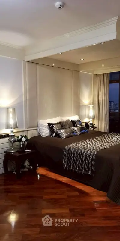 Luxurious bedroom with elegant decor and city view, featuring plush bedding and ambient lighting.
