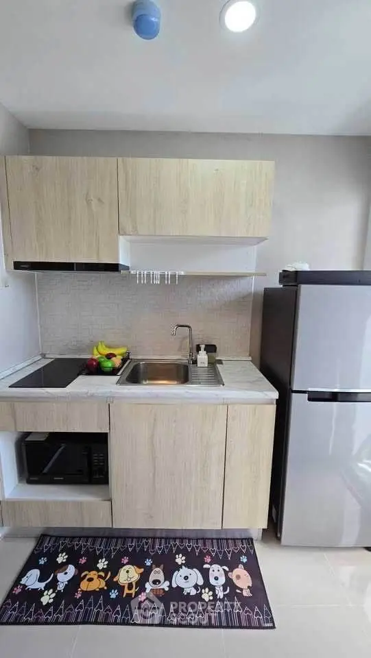 Modern compact kitchen with wooden cabinets and stainless steel appliances