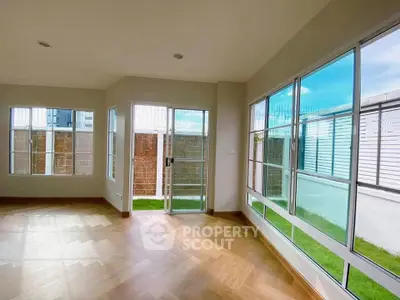 Spacious corner unit with large windows and wooden flooring, offering abundant natural light and garden view.