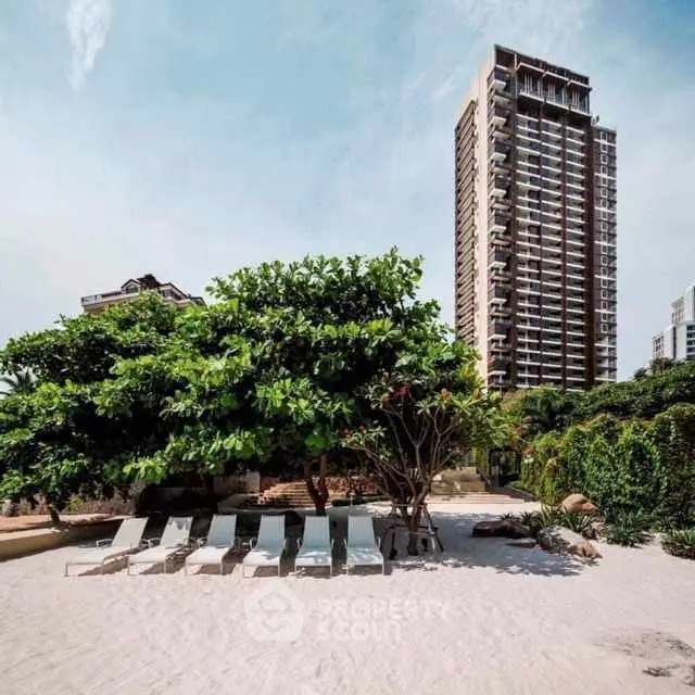 Luxurious beachfront property with high-rise building and lush greenery.