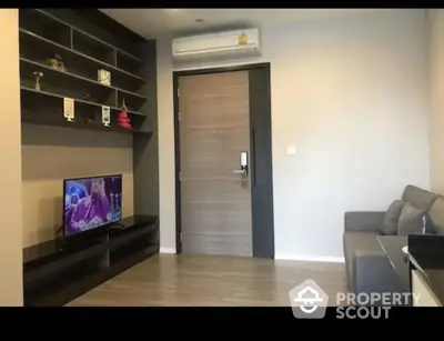 Modern living room with sleek design, featuring a wall-mounted TV and stylish shelving.