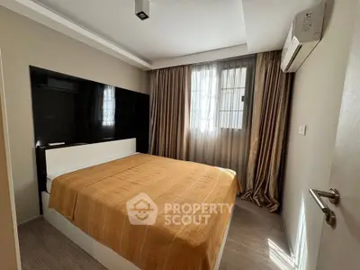 Cozy bedroom with modern decor and natural light, featuring a comfortable bed and air conditioning.